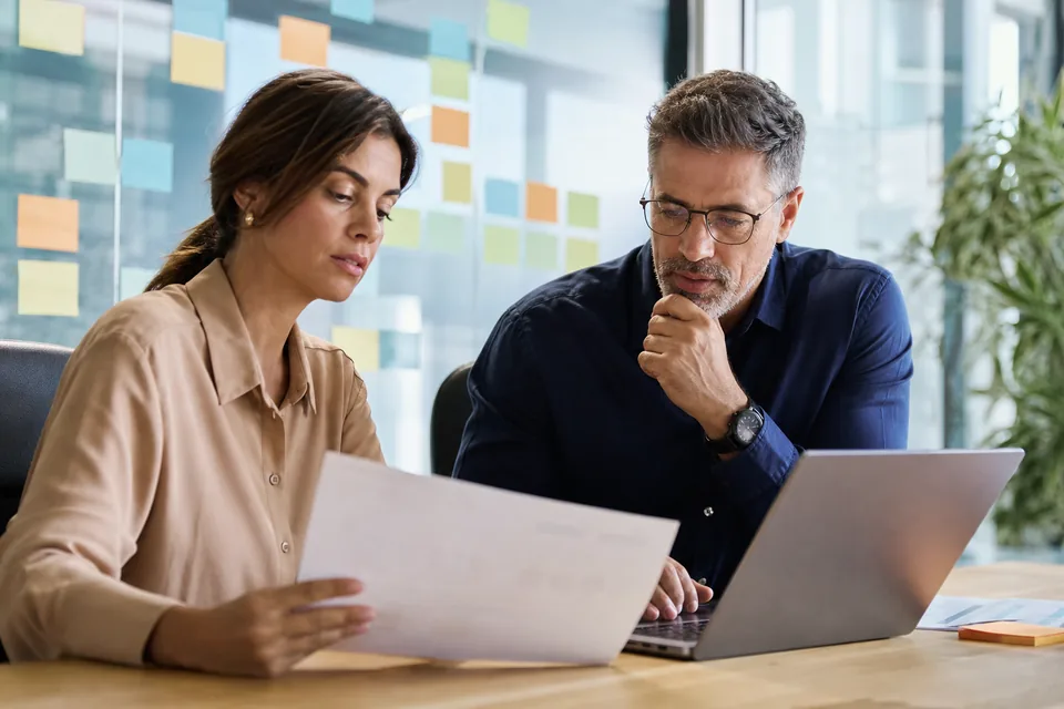 Product marketing manager and sales enablement lead reviewing a competitive intelligence contract and budget